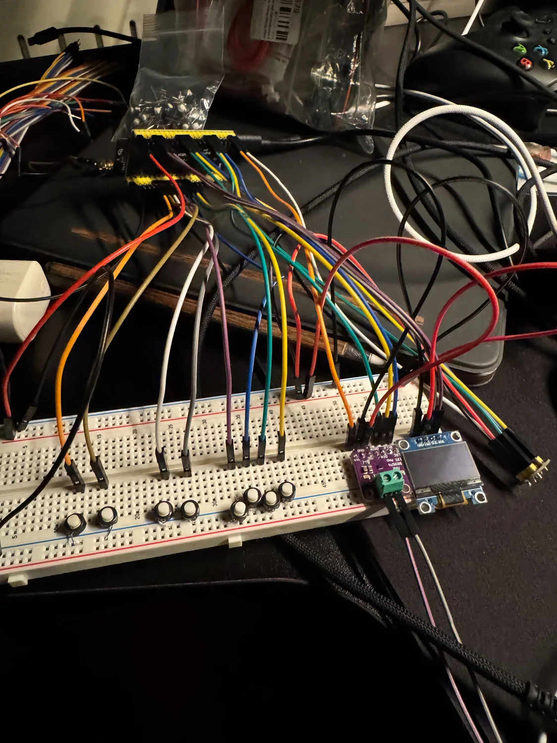 The early Brickphone breadboard, with eight push buttons and coloured jumper wires connected to the microcontroller and OLED.