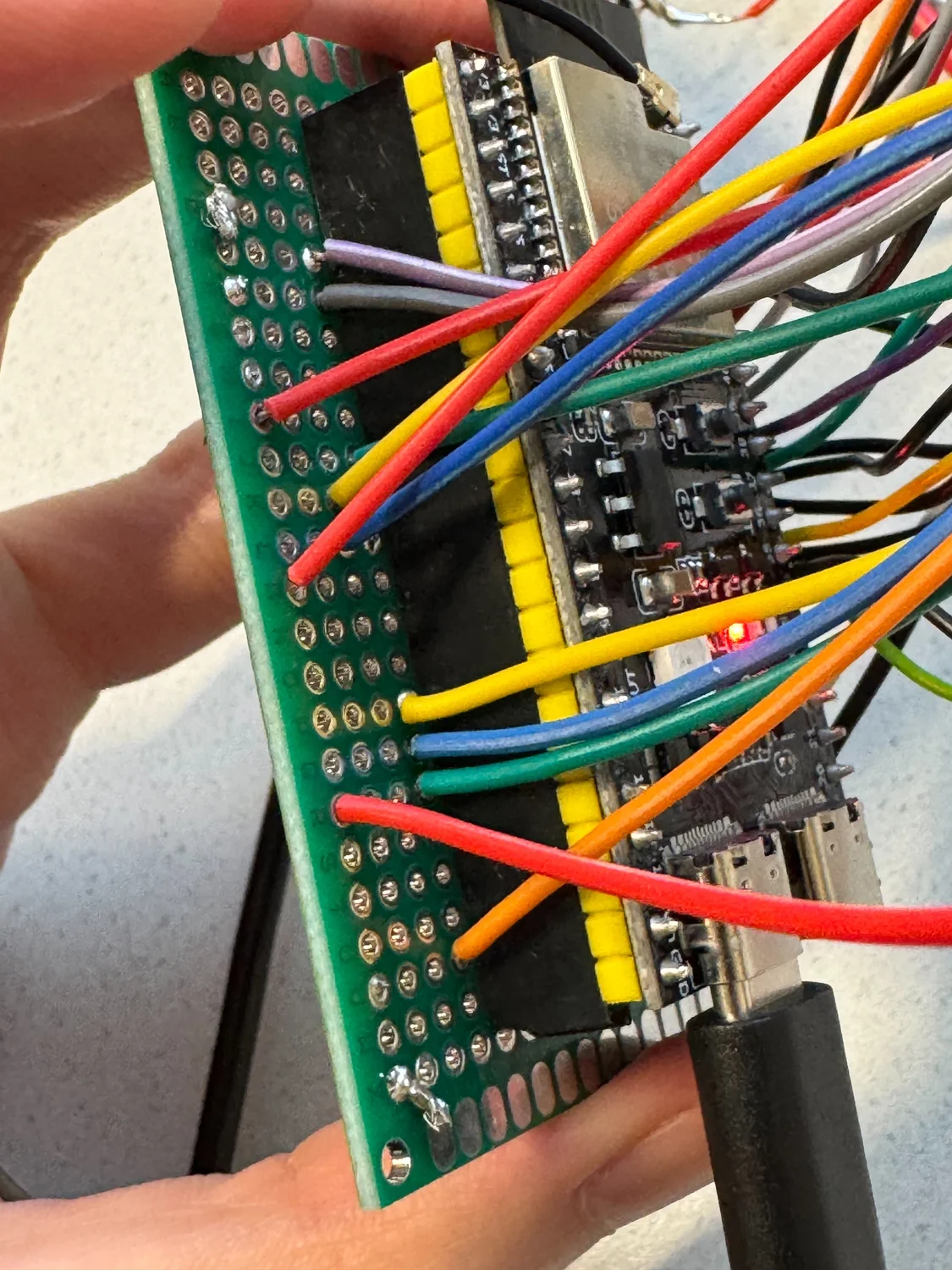 A close view of the ESP32 mounted against perfboard, surrounded by coloured wires inside the prototype assembly.